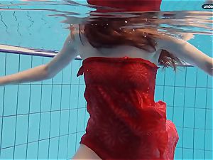 crimson dressed nubile swimming with her eyes opened