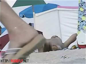 Beach bombshells drape out nude below the sun